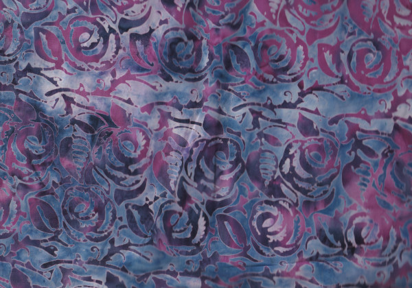 Batikstoff in Blau mit Lila Rosenmuster.